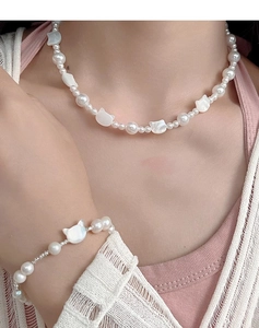 Detailed view of s925 silver cat and pearl necklace set worn on a model for display