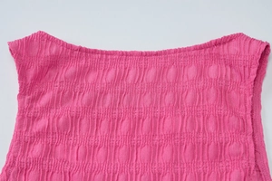 Détail du tissu froncé rose avec texture plissée élastique et encolure droite nette
