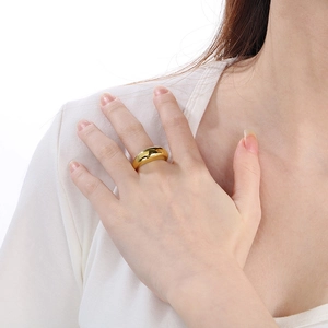 Close-up of a chunky 18k gold plated dome ring with a mirror polished surface finish