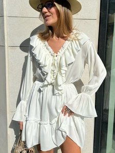 Detailed view of white chiffon V-neck dress with ruffles, drawstring tie and flared sleeves
