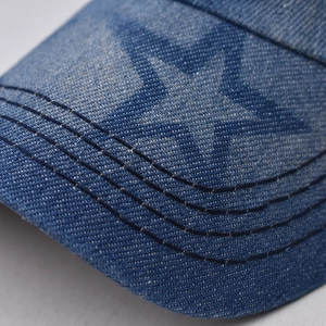 Vue macro d'une casquette en denim bleu délavé avec coutures décoratives et motifs d'étoiles