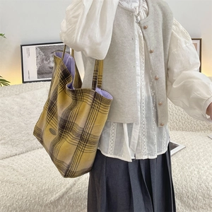 Detail of vintage yellow plaid woolen tote bag with purple lining and logo patch