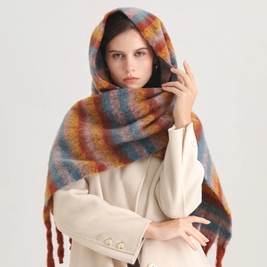 Detail of soft colorful plaid scarf with tassels styled on a model in a studio setting