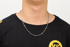 Detail view of unisex stainless steel chain necklace with cylindrical metal tubes on neck