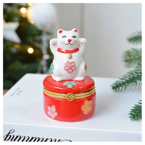 Detailed view of white Maneki Neko ceramic jewelry box with gold clasp and floral patterns