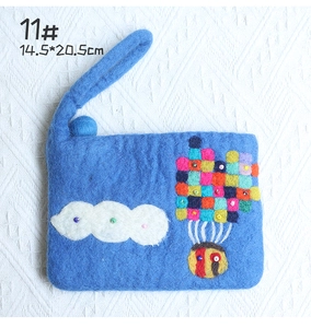 Macro detail of blue handmade wool felt pouch with colorful floral patterns and 14.5x20.5cm size