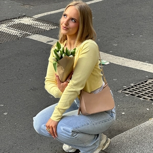 Photo de style urbain d'un sac à main marron clair assorti à un haut jaune tendance