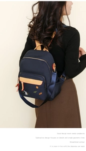 Detail of navy nylon backpack with rabbit embroidery and brown leather handle