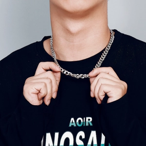 Close-up of men's silver Cuban link chain necklace shown on a model neck with steel texture