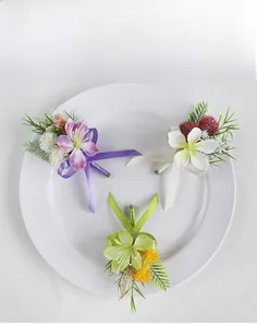 Detail view of purple and white jasmine boutonnieres with ribbon on a white plate
