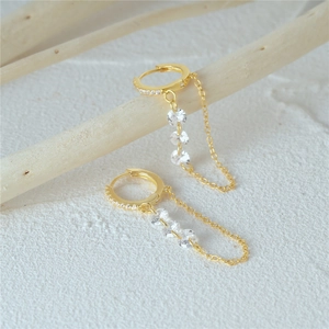 Detail of S925 silver hoop earrings with gold plating, hanging chains and clear crystals