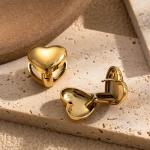 Polished gold heart hoop earrings in stainless steel on a natural stone base