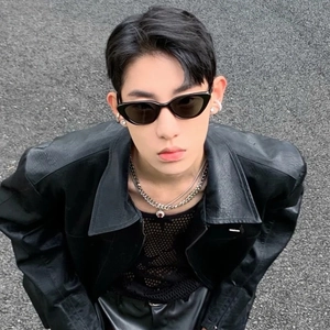 Close-up of black cat-eye sunglasses paired with leather jacket and silver chain