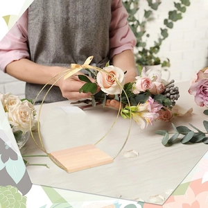 Close-up of golden metal floral hoop with wooden base for wedding table centerpieces