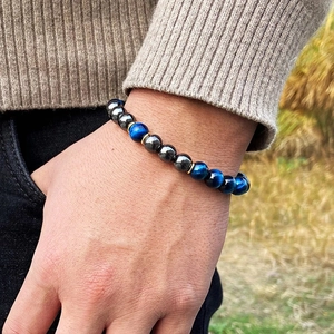 Neutral 8mm blue tiger eye beaded bracelet with hematite and gold spacers on a wrist