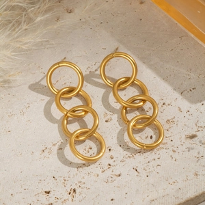 Macro shot of 18K gold plated multi-link chain earrings on a natural stone surface