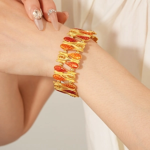 Detail of vintage teardrop zircon bracelet with orange and red gradient on gold finish