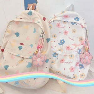 Detail showing two floral canvas backpacks with cute flower pendants and zippers
