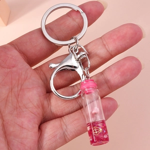 Close-up of pink wishing bottle keychain with dry flower and gold diamond charm