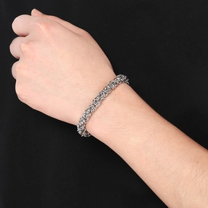 Nahaufnahme eines silbernen Titanstahl-Byzanz-Armbands am Handgelenk auf schwarzem Grund
