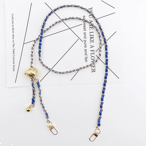 Detail of blue leather woven chain strap with gold metal accents and adjustable ball bead