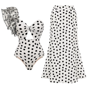 Close-up of polka dot swimsuit with ruffle shoulder and matching wrap maxi skirt