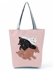 Detail of pink tote bag with cute cartoon cat illustration and gray handles