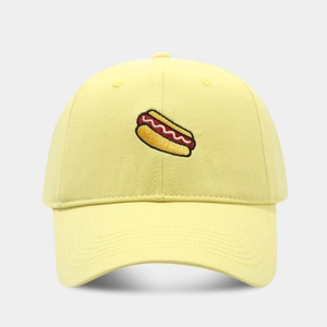 Detailed close-up of a bright yellow baseball cap featuring a hot dog pattern embroidery