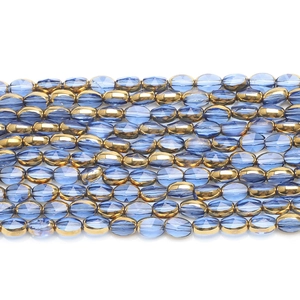 Macro detail of multifaceted 6x8mm blue glass beads and gold metallic spacers