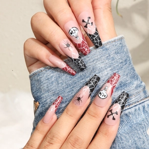 Long Halloween press-on nails with skull and spider web designs for trendy hand manicure