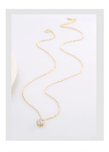 Close-up of gold S925 silver necklace with a transparent round zircon pendant detail