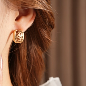 Gros plan de boucles d'oreilles dorées à motif léopard portées par un mannequin