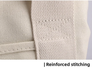 Close-up of reinforced cross-stitching on durable cream canvas handbag handle