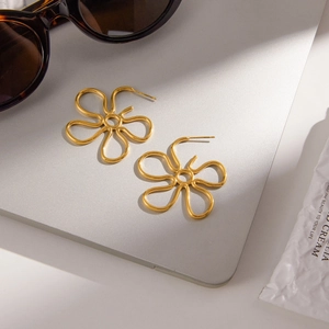 Elegant gold flower earrings in hollow petal design on a minimalist background