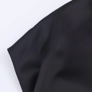 Gros plan sur le tissu noir soyeux haut de gamme avec détails de couture sur la jupe