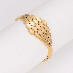 Irregular honeycomb gold bangle with layered oval plates and beaded edges on stand