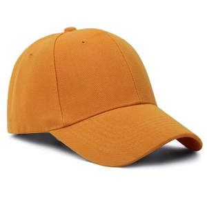Detail shot of a bright orange baseball cap with cotton twill texture and six panels