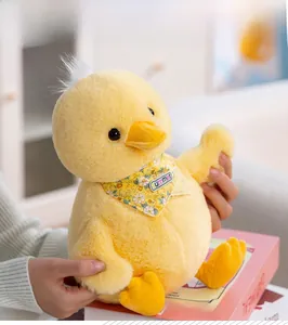 Detail of yellow plush duck doll with Summer bib and soft texture on pink prop box