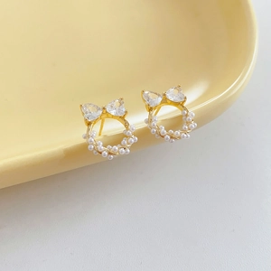 Détail de boucles d'oreilles nœud perle et zircon sur une assiette décorative