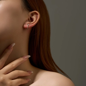 Close-up of S925 sterling silver hoop earring with teardrop zircon worn by a model
