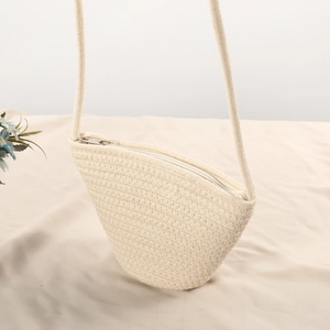 Detail of cream cotton woven mini shell bag with silver zipper and textured surface