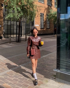 Outdoor Streetstyle-Aufnahme von braunem PU-Leder-Set aus Jacke und Minirock