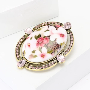 Baroque style oval brooch with flower patterns and pink teardrop crystal accents