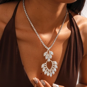 Close-up of a silver hollow teardrop pendant necklace with zircon floral patterns