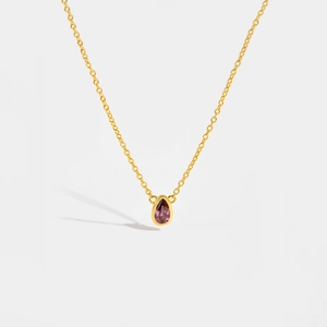 Detailed close-up of a pear-cut purple gemstone pendant on a golden S925 silver chain