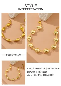 Detailed close-up of gold geometric charm bracelets with oval and teardrop link designs