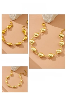 Detailed close-up of gold geometric charm bracelets with oval and teardrop link designs