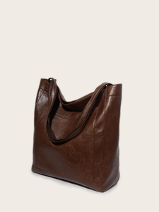 Détail de la texture d'un grand sac cabas en cuir ciré vintage marron foncé à anses