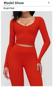 Détail du haut court à manches longues col en V rouge et legging de yoga taille haute