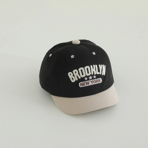 Detailed embroidery of BROOKLYN lettering on a two-tone knit toddler baseball cap